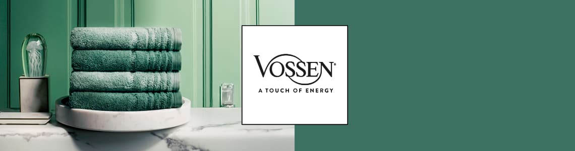 Vossen – A Touch of Energy. Drei grüne Handtücher auf einem weißen Teller auf einer Marmoroberfläche vor grünem Hintergrund.