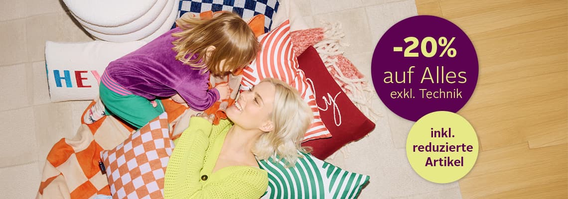 -20 % auf Alles exkl. Technik, inkl. reduzierte Artikel – Kind und Erwachsene liegen auf bunten Kissen auf dem Boden