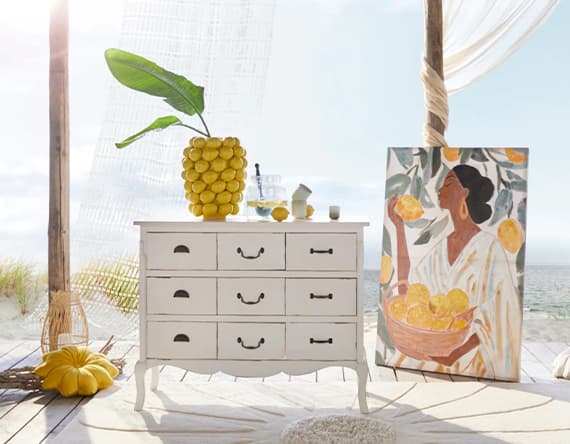 Zitronenvase, gelbes Kissen und Bild mit Zitronen