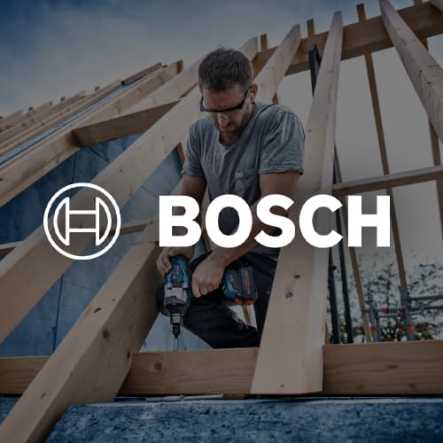 BOSCH – Mann arbeitet mit Akkuschrauber auf einem Holzgerüst für Dachkonstruktion