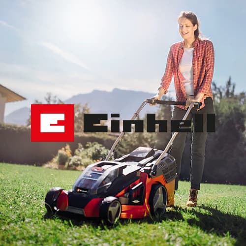 Einhell – Person mäht Rasen mit rotem Rasenmäher im Garten, Berge im Hintergrund