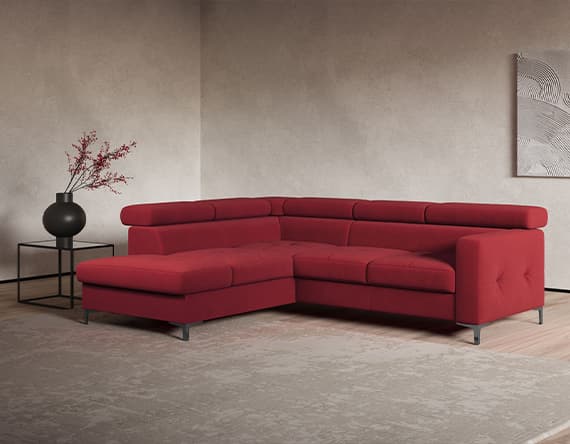 Rotes Ecksofa in modernem Wohnzimmer mit Teppich, schwarzer Vase auf Tisch und abstraktem Wandbild