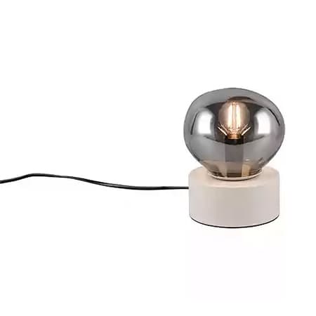Moderne Tischlampe mit rundem, silbernem Leuchtkörper und weißem Sockel, schwarzes Kabel liegt daneben