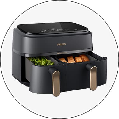 Philips Heißluftfritteuse mit geöffneter Schublade, gefüllt mit Brokkoli und Pommes