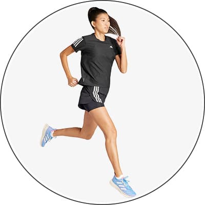 Frau in Sportkleidung und blauen Turnschuhen joggt.