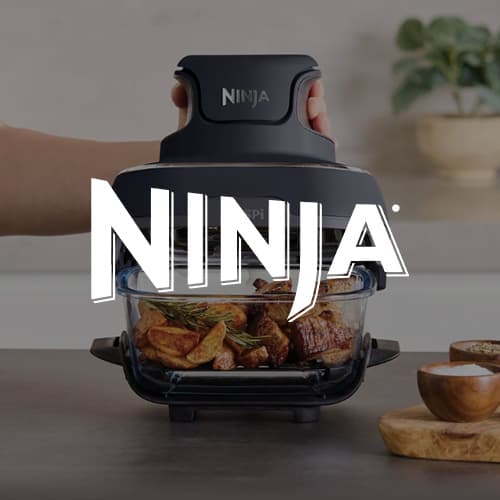 Ninja – Hand hebt Deckel von Glasbehälter mit gebratenem Fleisch und Kartoffeln in moderner Küche