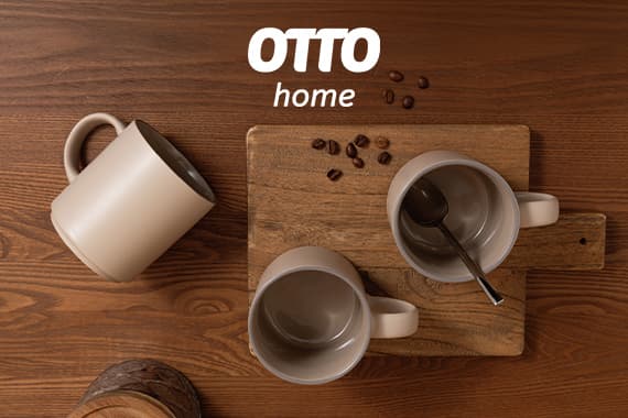 OTTO home – drei beige Tassen auf Holztisch, eine umgekippt, daneben Brett mit Löffel und verstreuten Kaffeebohnen