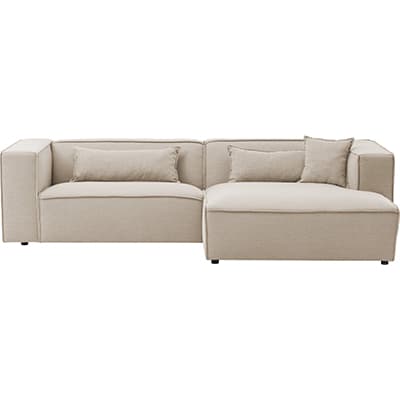 Beiges Ecksofa mit breiten Armlehnen, rechts langer Ottomanenteil und zwei passenden Rückenkissen