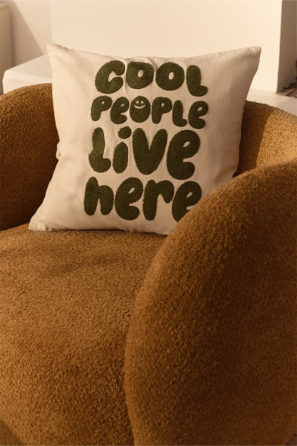 COOL PEOPLE LIVE HERE – quadratisches Zierkissen mit Schriftzug auf rundem Sessel
