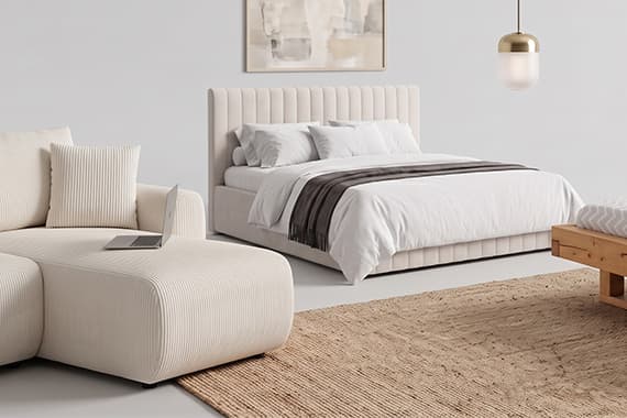 Modernes Schlafzimmer mit Polsterbett, Sofa, Holzbank und Teppich in hellen Naturtönen