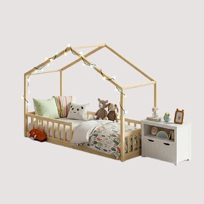 Kinderbett im Haus-Design mit Lichterkette, bunter Bettwäsche, Kuscheltieren und weißem Nachttisch mit Spielzeug