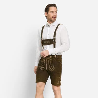 Mann trägt weiße Trachtenbluse und braune Lederhose mit Hosenträgern.