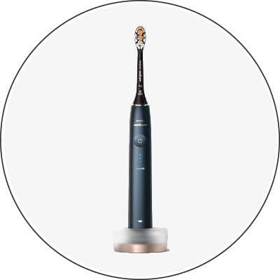 Schwarze elektrische Zahnbürste mit weißem Borstenkopf auf Ladegerät, frontal abgebildet
