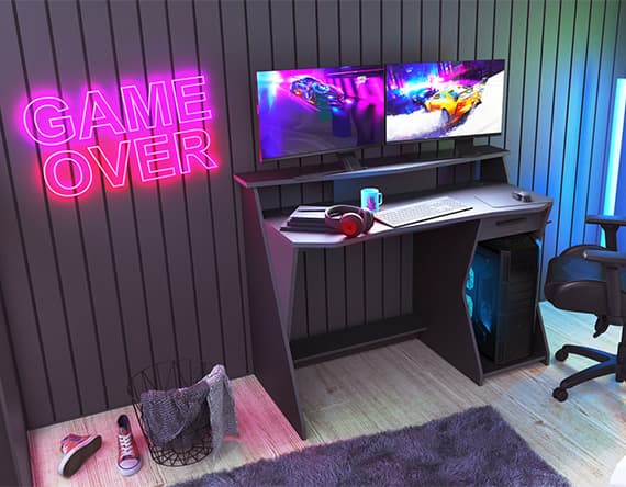 Gaming-Schreibtisch mit zwei Monitoren, Tastatur, Maus und Headset, daneben ein Stuhl und ein Wäschekorb