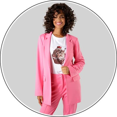 Frau trägt rosa Anzug und weißes T-Shirt mit Cupcake-Aufdruck, Gesicht unscharf