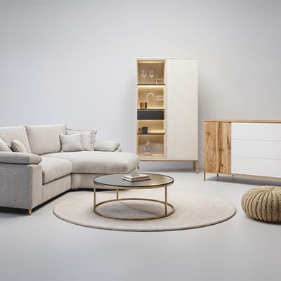 Moderne Wohnzimmermöbel – graues Ecksofa, runder Couchtisch, Schrank mit offenen Regalfächern, Kommode und runder Teppich