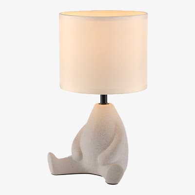 Tischlampe mit einem Sockel in Form eines sitzenden Bären und einem großen, runden Lampenschirm, der warmes Licht ausstrahlt.