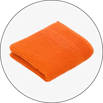 Gefaltetes, orangefarbenes Handtuch mit Streifenmuster auf weißem Hintergrund