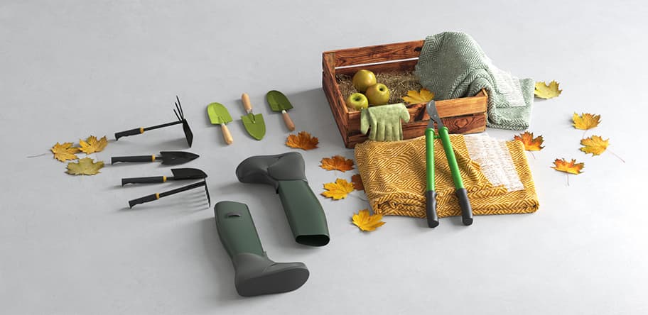 Herbstliche Gartenszene mit Werkzeugen, grünen Gummistiefeln, Kiste mit Äpfeln und Handschuhen, umgeben von gefallenen Blättern