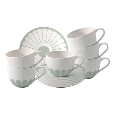 Set aus sechs weißen Tassen und Untertellern mit grünem Blütenmuster, gestapelt und arrangiert für Präsentation