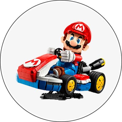 LEGO Mario in rotem Rennwagen mit gelben Rädern und rotem Helm, fährt und lächelt