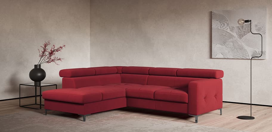 Rotes Ecksofa in modernem Wohnzimmer mit grauer Wand, schwarzer Stehlampe, schwarzem Beistelltisch und Vase mit Zweigen