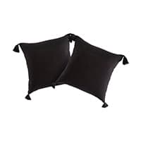 Zwei schwarze Kissen mit Quasten an den Ecken liegen nebeneinander.