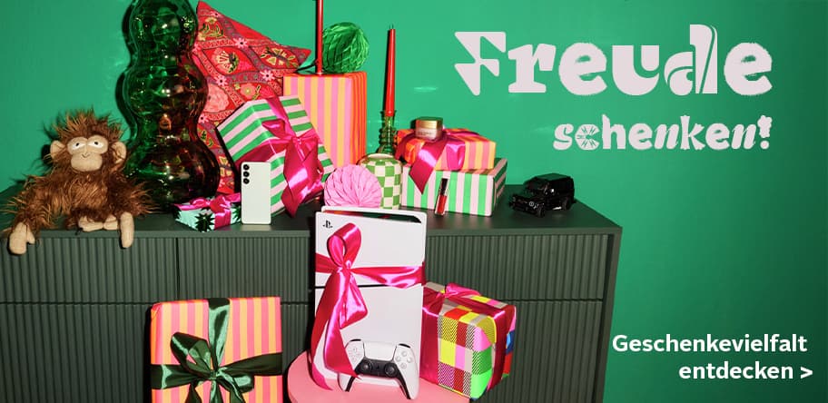 Freude schenken! Geschenkevielfalt entdecken – bunte Geschenke auf einem grünen Schrank, Stoffaffe, PlayStation und Dekoobjekte