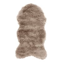 Brauner, flauschiger Teppich in Form einer Tierhaut auf weißem Hintergrund