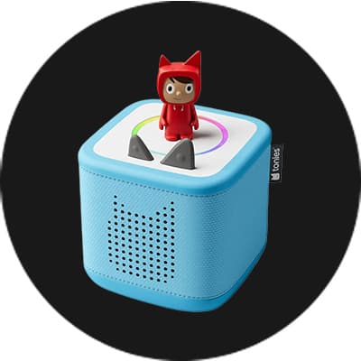 Blaue Toniebox mit Spielfigur in rotem Katzenkostüm auf schwarzem Hintergrund