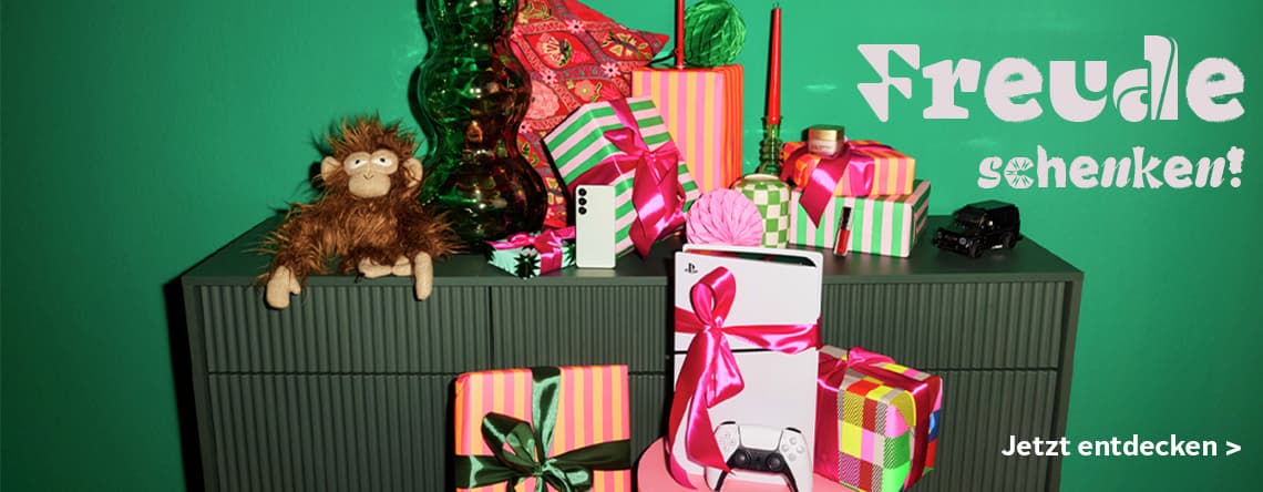 Freude schenken! Jetzt entdecken > Verschiedenfarbige Geschenke, Stoffaffe und Playstation auf grünem Schrank
