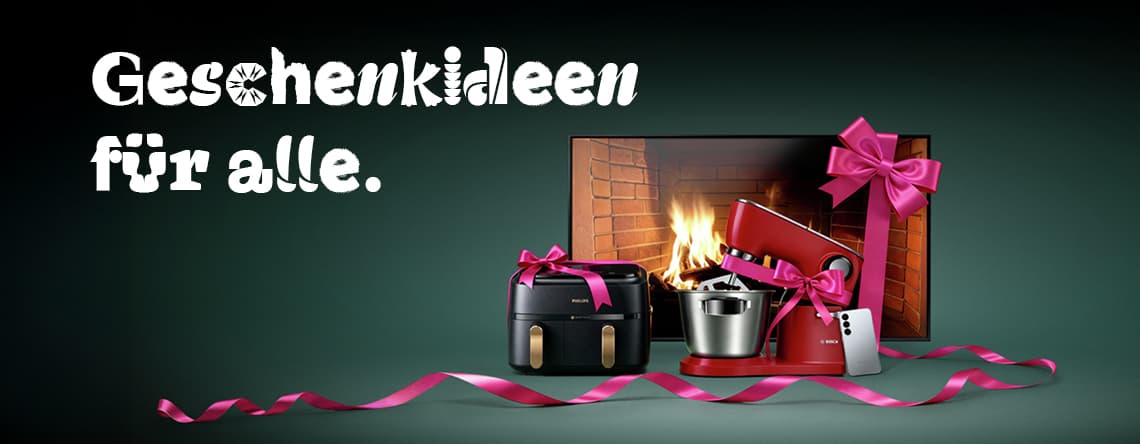 Geschenkideen für alle – Küchengeräte und Smartphone vor Kamin, dekoriert mit rosa Schleifen und Geschenkband