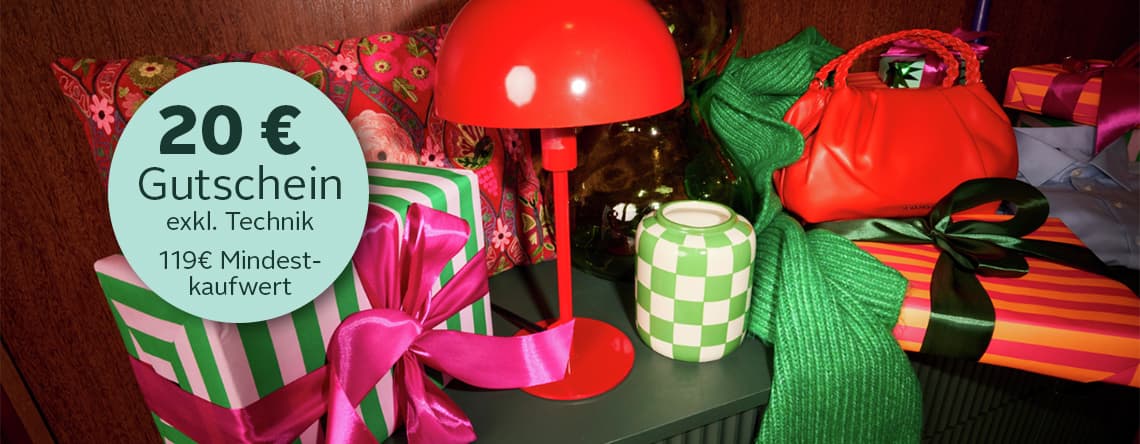 20€ Gutschein – 119€ Mindestkaufwert, Geschenke mit bunten Schleifen und eine rote Lampe auf einem Tisch