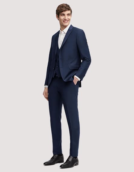 Mann trägt dunkelblauen Anzug mit weißem Hemd und schwarzen Schuhen.