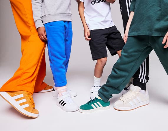 Gruppe von Personen zeigt verschiedene Sneaker in bunten Hosen.