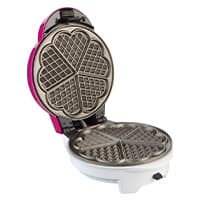Geöffneter Waffeleisen mit herzförmigen Waffelformen auf weißem Hintergrund.
