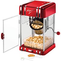 Rot-weiße Popcornmaschine mit offenem Glasfenster, frischem Popcorn und Messlöffel auf dem Tisch.