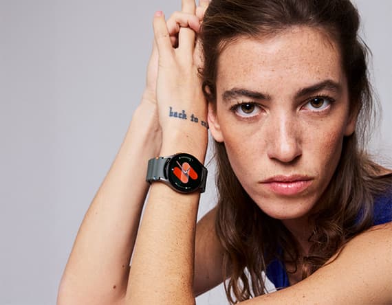 Person mit Tätowierung "back to..." trägt eine schwarze Smartwatch mit rotem Schmetterlingsdisplay.