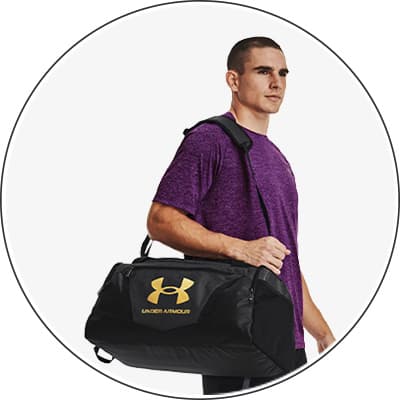 Mann in lila Shirt trägt schwarze Under Armour Sporttasche über der Schulter