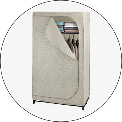 Stoffkleiderschrank mit geöffneter Front, zeigt Kleidung und gefaltete Handtücher.