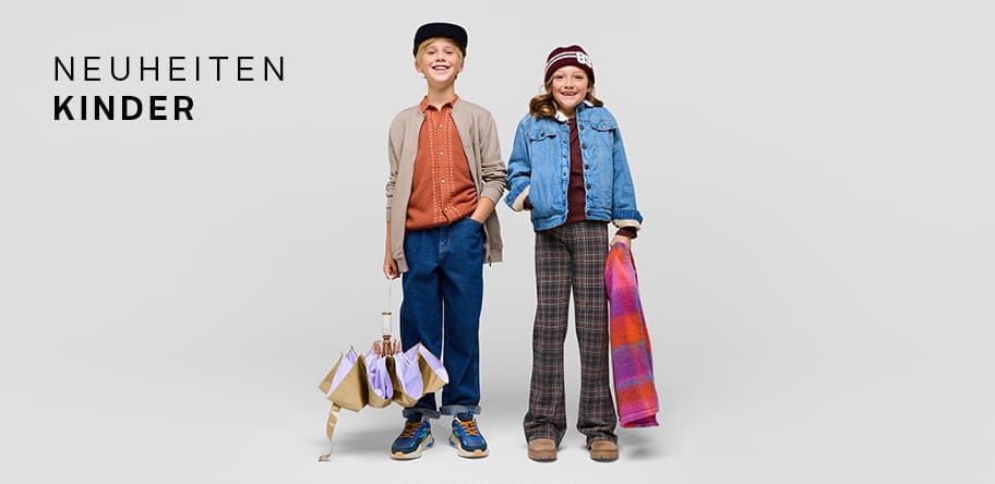 Neuheiten Kinder – Zwei Kinder in Herbstkleidung, eines hält einen Regenschirm, das andere eine bunte Tasche