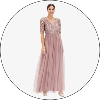 Frau trägt rosafarbenes Abendkleid mit Paillettenoberteil und Tüllrock.