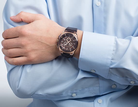 Arm mit Uhr in Nahaufnahme – Mann trägt eine blaue Uhr und ein hellblaues Hemd