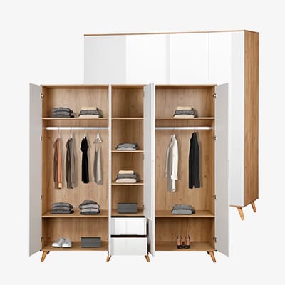 Großer weißer Kleiderschrank mit fünf Türen und zwei Schubladen auf Holzfüßen.
