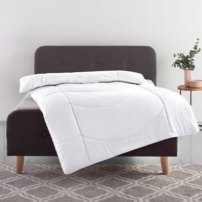 Weiße Bettdecke auf schwarzem Bett in modernem Schlafzimmer mit Pflanze auf Nachttisch