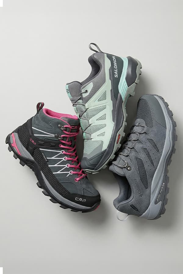 Drei graue Outdoorschuhe in unterschiedlichen Designs liegen kreisförmig auf hellem Hintergrund