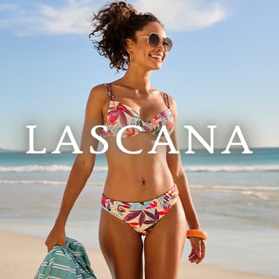 LASCANA – Frau im bunten Bikini geht am sonnigen Sandstrand entlang und hält ein gestreiftes Handtuch in der Hand