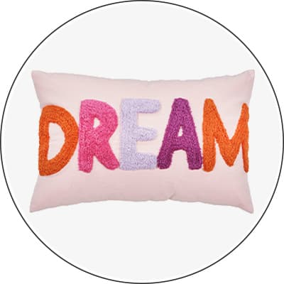 DREAM – rechteckiges Kissen mit bunten Buchstaben auf hellem Hintergrund