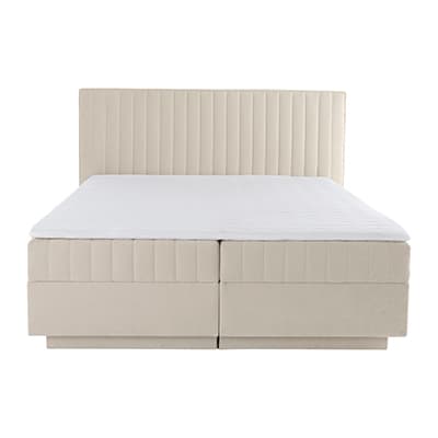 Doppelbett mit hoher, gesteppt wirkender Rückenlehne und schlichtem, geradlinigem Bettkasten von vorn gesehen