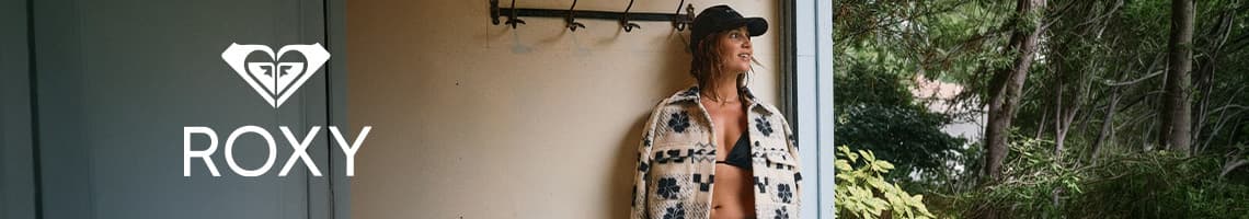 ROXY Logo links, rechts Frau im gemusterten offenen Mantel und Bikinioberteil steht im Türrahmen vor Bäumen